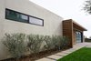 Modern home with Exterior, Walkways, Swing Door Type, Hardscapes, Horizontal Fences, Wall, Wood Fences, Wall, Concrete Patio, Porch, Deck, Attached Garage Room Type, Stone Patio, Porch, Deck, Gardens, Decomposed Granite Patio, Porch, Deck, and Outdoor. A linear metal window and increased roof height at the stucco parapet adds visual interest and subtle movement at the home's exterior massing. Photo 5 of Laguna Niguel Mid-Century