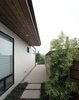 Modern home with Walkways, Hardscapes, Exterior, Swing Door Type, Horizontal Fences, Wall, Wood Fences, Wall, Decomposed Granite Patio, Porch, Deck, Concrete Patio, Porch, Deck, Attached Garage Room Type, Grass, Stone Patio, Porch, Deck, Small Patio, Porch, Deck, Shrubs, Outdoor, and Side Yard. Cedar clads the new awnings at rear and side yards, while offset cedar slats provide for privacy and design continuity at the new fencing. Photo 7 of Laguna Niguel Mid-Century