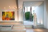 Modern home with Living Room, Ceiling Lighting, Floor Lighting, and Concrete Floor. The front entrance opens into the great room next to a linear pond. The home becomes a perfect showcase for the owner's artwork collection. Photo 2 of Desert Canopy House