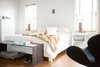 The minimalistic planes of a Giulio Lazzotti plywood bench flirt with the curves of an Arne Jacabson Swan chair, both adding contrast to the predominantly white room. Photo 15 of SOMO: southern mod modern home