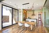 Modern home with Dining Room, Chair, Ceiling Lighting, Table, Medium Hardwood Floor, Stools, Pendant Lighting, Bar, and Recessed Lighting. The bright and airy open floor plan features hardwood floors that are made from reclaimed wood from Kentucky horse farm fences. Shown is a reclaimed wood dining room table by Rework Collective and a biophilic chandelier from Honest Home by local Artist Leah Naomi. Photo 10 of A Zero-Energy Modern, Italianate Home for sale in the Louisville, KY area.
