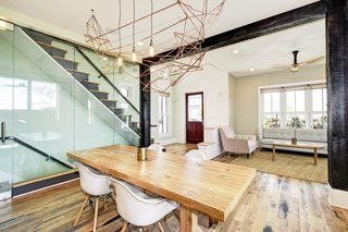 Reclaimed barn wood columns and beams treated with the shou sugi ban technique function to define the dining room and living/foyer spaces. An architectural glass wall creates a view of the floating staircase.