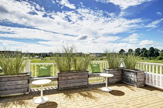 Reclaimed barn wood planter boxes on the second-floor rooftop terrace feature built-in benches and recycled rubber roof pavers.