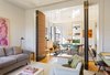 The opening between the living room and dining area was enlarged and large custom upholstered acoustical panels were added to create a flexible bedroom. Photo of A Chelsea Apartment modern home