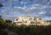 Modern home with Exterior, Metal Roof Material, and House Building Type. The house is clad in the region’s typical cedar shingles to blend in with its surroundings and the massing is broken down into different volumes so as to appear more settled in the landscape. Photo 2 of Meadow Beach House