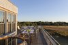Modern home with Outdoor, Large Patio, Porch, Deck, and Wood Patio, Porch, Deck. The second floor deck is surrounded by the adjacent meadows, with views and sounds of the nearby ocean. Photo 12 of Meadow Beach House