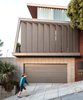 Modern home with Exterior, Shed RoofLine, Mid-Century Building Type, Metal Roof Material, Concrete Siding Material, House Building Type, Wood Siding Material, and Glass Siding Material. Steep street. Original garage door and wooden louvers. New third floor glass louvers. Photo 12 of Schindler Residence