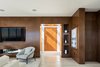 Modern home with Living Room, Accent Lighting, Ceiling Lighting, Sectional, Light Hardwood Floor, Gas Burning Fireplace, Ribbon Fireplace, Bookcase, Recessed Lighting, Chair, Sofa, and Limestone Floor. Reclaimed Walnut and View to Stairway Skylight Photo 4 of Minimal House One