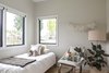 Modern home with Bedroom, Bed, Chair, and Light Hardwood Floor. Monochromatic neutrals and organic textures create a Southern California beach vibe in this toddler's room. Windows: Integrity by Marvin Photo 13 of Open and Airy Whole-Home Remodel