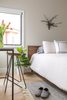 Modern home with Bedroom, Bed, and Light Hardwood Floor. A modern bed with wood headboard and industrial writing desk. Windows: Integrity by Marvin. Photo 8 of Open and Airy Whole-Home Remodel