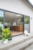 A concrete patio leads to this dramatic entry between an indoor/outdoor living and entertaining space. Sliding Door: La Cantina; Pendant Fixtures: Dot Suspension by Lambert et Fils. Photo 16 of Open and Airy Whole-Home Remodel modern home