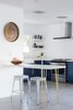 Modern home with Kitchen, Colorful Cabinet, Drop In Sink, Concrete Floor, Granite Counter, Ceiling Lighting, and Recessed Lighting. The blue theme continues in the kitchen along with a brass legged built in breakfast table. Photo 6 of This Palm Springs Gem Gets A Modern Makeover With A Bohemian Twist