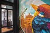 A four story courtyard is encased in all steel and glass windows for three of the walls, creating a transparent view of the interiors on each floor, and the fourth wall displays a larger than life custom mural by a local Cincinnati artist highlighting scenes from the local downtown market. Photo 18 of Over-The-Rhine Urban Revival modern home