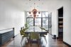 Modern home with Dining Room, Pendant Lighting, Chair, Table, Medium Hardwood Floor, and Table Lighting. On the second floor they created one large continuous space complete with multiple seating areas, a large kitchen, and a dining room that accommodates 14, as the homeowners routinely host neighborhood dinners on Sundays. Photo 4 of Over-The-Rhine Urban Revival
