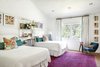 Modern home with Bedroom. Two of the girls share a bedroom that keeps the theme of light and bright, with pops of fun colors in the rug and accessories. Photo 7 of Light Filled House For Ten