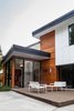 While maintaining the existing house structure, an entirely new, modern home was created from new interiors placed on to a new exterior skin. The entire exterior was revised with new cladding, metal roof, insulation, and windows. An addition opened the space to embrace higher ceilings and to introduce varying floor levels in order to create a fresh, dynamic flow within the home. The re-cladding of the house allowed for a complete change in the home’s style while also completing significant thermal improvements. Photo of Creek Drive Residence modern home