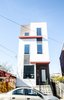 The row house façade takes a playful tone, with a mix of exterior cladding materials and horizontal red projections dividing up the three stories and making the narrow parcel stand out. Photo 3 of Charlotte Street Residence modern home