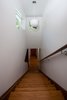 A walnut stair case connects the second floor to the third floor addition. Now a master suite, the addition contains the master bedroom, bathroom and a private deck. New windows, exterior cladding and paint at the existing house tied the addition in. Photo of Highland Park Residence modern home