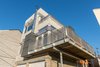 Custom designed galvanized steel and aluminum bar grating sunshades add a layer of detail and articulation to the exterior design, while eliminating glare and heat gain from direct sunlight to interior spaces. Photo 5 of Ligonier Street Residence modern home