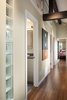 Windows at the right (out of view) spill natural light into this extended hallway where a bathroom, laundry room and a third bedroom have been added. Beam details match those used elsewhere in the home. Glass blocks allows light into closet and master bathroom. Vaulted ceilings allow for "attic storage" accessible via new doors high up on the wall. Photo 9 of The Ping Pong Home modern home