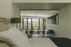 The bedroom captures the view over the void of the living space and out into the treetops. Photo 8 of Eco 234 modern home