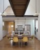 Modern home with Dining Room, Light Hardwood Floor, Pendant Lighting, and Chair. view of dining and kitchen with bridge above Photo of Bridge House