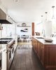 Modern home with Kitchen, Quartzite Counter, Range, Range Hood, Porcelain Tile Floor, Wood Cabinet, White Cabinet, Ceramic Tile Backsplashe, Pendant Lighting, and Undermount Sink. kitchen island and breakfast nook Photo 5 of Wild Way Remodel