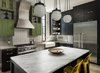 Modern home with Kitchen, Marble Counter, Wood Cabinet, Dark Hardwood Floor, Concrete Counter, Subway Tile Backsplashe, Pendant Lighting, Concrete Backsplashe, Range, Range Hood, Dishwasher, and Refrigerator. The kitchen is the heart of the home, and its design was carefully appointed with craftwork by local artisans. Brass pulls were custom designed and crafted to suit the space. The metal mesh on the upper cabinets was replicated with milled details in the cabinets beneath them. Concrete and marble counter tops provided a solid balance of industrial design and luxury. Photo 9 of 400SOLA