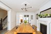 Modern home with Dining Room, Chair, Accent Lighting, Standard Layout Fireplace, Table, Pendant Lighting, Wood Burning Fireplace, Medium Hardwood Floor, and Light Hardwood Floor. Dining Room: salvaged fireplace restores the authentic 1899 dining room while adding modern tiles and pop of colour Photo 6 of Brooklyn Brownstone