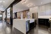 Modern home with Kitchen, Dishwasher, White Cabinet, Pendant Lighting, Undermount Sink, Marble Counter, Ceiling Lighting, Dark Hardwood Floor, Recessed Lighting, and Refrigerator. The black and white DIY cabinet faces match the exposed beam that stretches across the living space on the first floor. Photo 4 of Denver Home