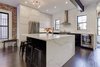 Modern home with Kitchen, Range Hood, Beverage Center, Range, Dark Hardwood Floor, Ceiling Lighting, Recessed Lighting, Refrigerator, Marble Counter, White Cabinet, and Ceramic Tile Backsplashe. Our DIY Shaker doors are professionally painted with industrial-grade acrylic. Photo of Denver Home