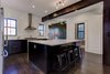Modern home with Kitchen, Recessed Lighting, Ceiling Lighting, Range Hood, Ceramic Tile Backsplashe, Range, Dark Hardwood Floor, and Marble Counter. A custom flat panel on one side of the island. Photo 2 of Denver Home