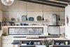 Modern home with Kitchen, Range Hood, Cooktops, Ceiling Lighting, Laminate Counter, Pendant Lighting, Laminate Cabinet, Track Lighting, Brick Backsplashe, Concrete Floor, and Drop In Sink. Kitchen Photo 5 of The Golf Course House