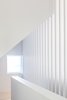 Modern home with Staircase, Wood Railing, and Wood Tread. Small punched window brings morning light into second and third floors along stairwell Photo 14 of House Grace