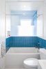 Modern home with Bath Room, Engineered Quartz Counter, Porcelain Tile Floor, Undermount Sink, Alcove Tub, Ceiling Lighting, Accent Lighting, Ceramic Tile Wall, Porcelain Tile Wall, and One Piece Toilet. Bathroom with borrowed light and view across a double height volume Photo 12 of House Grace