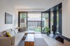 Modern home with Living Room, Sofa, Sectional, Coffee Tables, Accent Lighting, Wood Burning Fireplace, Corner Fireplace, Slate Floor, Medium Hardwood Floor, and Light Hardwood Floor. Living room opening out onto rear garden Photo 4 of House Grace