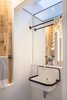 Modern home with Bath Room, Light Hardwood Floor, Medium Hardwood Floor, Wall Mount Sink, Ceiling Lighting, One Piece Toilet, and Accent Lighting. Powder room with borrowed light from glass ceiling over hung wall sink Photo 8 of House Grace