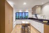 Modern home with Kitchen, Wall Oven, Refrigerator, Cooktops, Range Hood, White Cabinet, Wood Cabinet, Medium Hardwood Floor, Light Hardwood Floor, Stone Counter, Slate Floor, Stone Slab Backsplashe, Ceramic Tile Backsplashe, Ceiling Lighting, Accent Lighting, and Undermount Sink. Kitchen with custom floating tiled hood vent Photo 6 of House Grace