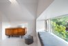 Modern home with Living Room, Console Tables, Ottomans, Light Hardwood Floor, Bench, and Table Lighting. Window nook overlooking neighbourhood trees and street Photo 15 of House Grace