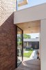 Modern home with Exterior, House Building Type, Wood Siding Material, Brick Siding Material, and Concrete Siding Material. Detail at new and old with garden and through garage beyond Photo 17 of House Grace
