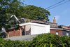 Modern home with Exterior, Shingles Roof Material, Green Roof Material, House Building Type, Wood Siding Material, Brick Siding Material, Concrete Siding Material, Metal Siding Material, A-Frame RoofLine, and Flat RoofLine. View of house amongst neighbours from rear lane Photo 19 of House Grace