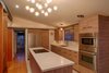 A new island replaces the house’s original pony wall, and new IKEA cabinets fit nicely into the spare design of the house. A pocket door next to the refrigerator conceals a small pantry. Photo 10 of Cliff May Homes RM 3212 modern home