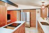 A new island replaces the house’s original pony wall, and new IKEA cabinets fit nicely into the spare design of the house. A pocket door next to the refrigerator conceals a small pantry. Photo 12 of Cliff May Homes RM 3212 modern home