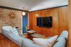 New wood paneling compliments the original brick of the fireplace. Original indirect lighting in the soffits above the wall has been maintained. Photo 13 of Cliff May Homes RM 3212 modern home
