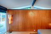Wood paneling and a vintage clock make for a sophisticated and cozy master suite. Photo 18 of Cliff May Homes RM 3212 modern home