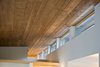 Modern home with Windows and Wood. The home seamlessly integrates a floating cedar tongue and groove roof with large sheltering overhangs, clerestory windows, and language of cedar slats for privacy screens and doors inside and out. The tops of these windows reveal the interior cedar clad and the up-swept soffits on the home’s exterior, creating a floating ceiling effect. Photo 10 of Cedar Haus