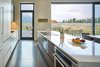 Modern home with Doors, Interior, Swing Door Type, Wood, Metal, Sliding Door Type, and Exterior. Just off the kitchen, clever “window walls” of Zola Windows enormous 24-foot triple Zola Lift & Slide door and large fixed units of 8-foot by 10-foot windows–with a custom matte metallic gray–surround the living room and direct one’s gaze to the panoramas unfolding beyond, while retaining an intimate connection with the natural sage-brush landscape. Photo 5 of House of Fir