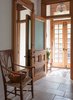 Modern home with Hallway, Limestone Floor, and Concrete Floor. The Entry Vestibule and Foyer feature a GLOBUS pendant by The Urban Electric Co., a beautifully restored mirror original to the house, and an antique wicker armchair from Europe. Antique Limestone flooring and handmade Cement Tile based on traditional Moroccan designs. Photo 3 of Harlem Brownstone