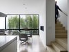 View of the Dining Room from the Kitchen. The Stairway, leading up to the Sun Room and down to the Master Bedroom Level (beyond), wraps around the Fireplace Wall. Photo 7 of Telegraph Hill Periscope modern home
