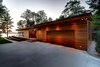 Full south side facade with cedar clad garage door Photo 6 of Higgins Lake House modern home